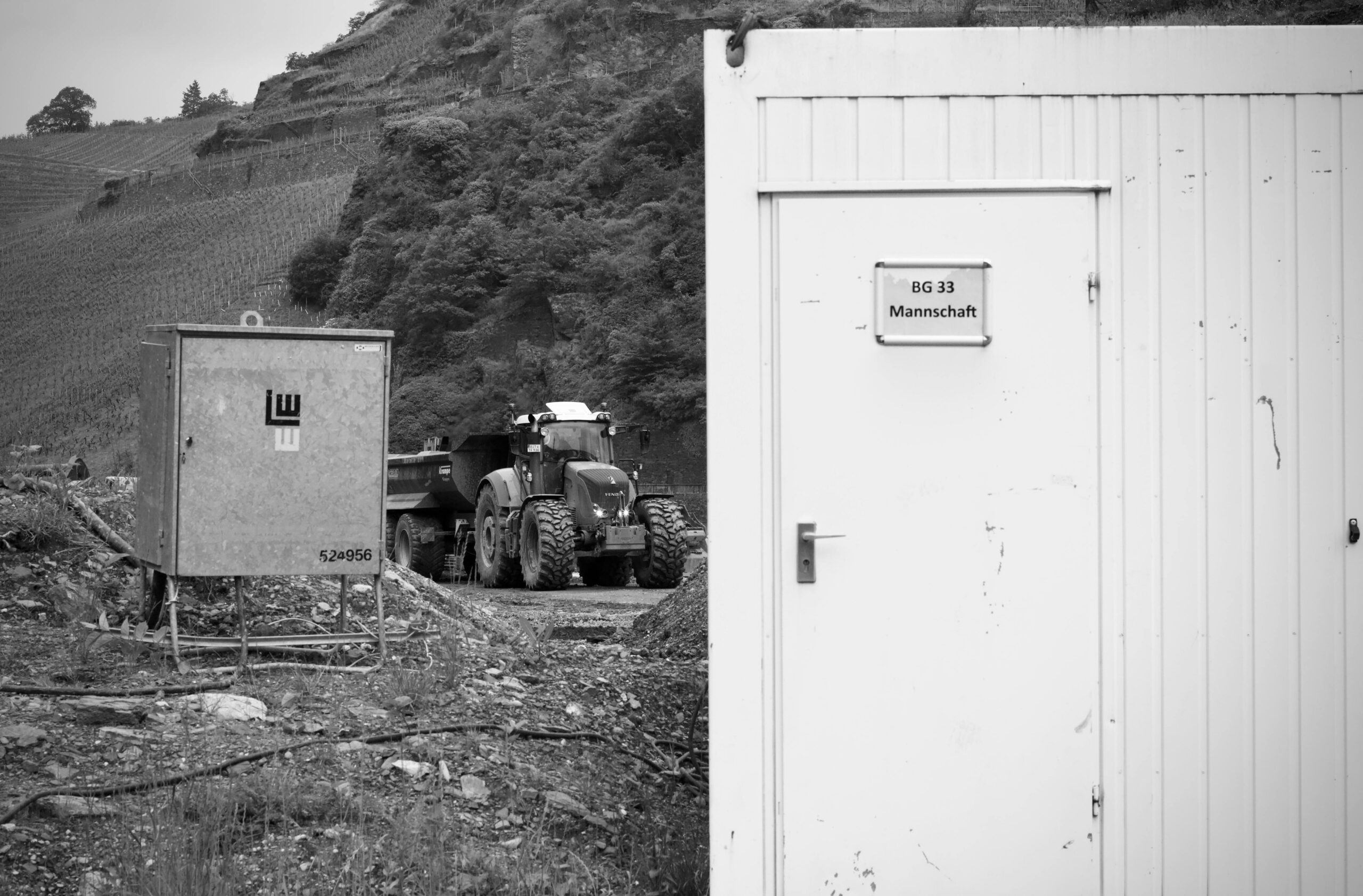 Industrieszene mit einem Traktor und Baustellenbereichen in monochromen Tönen.