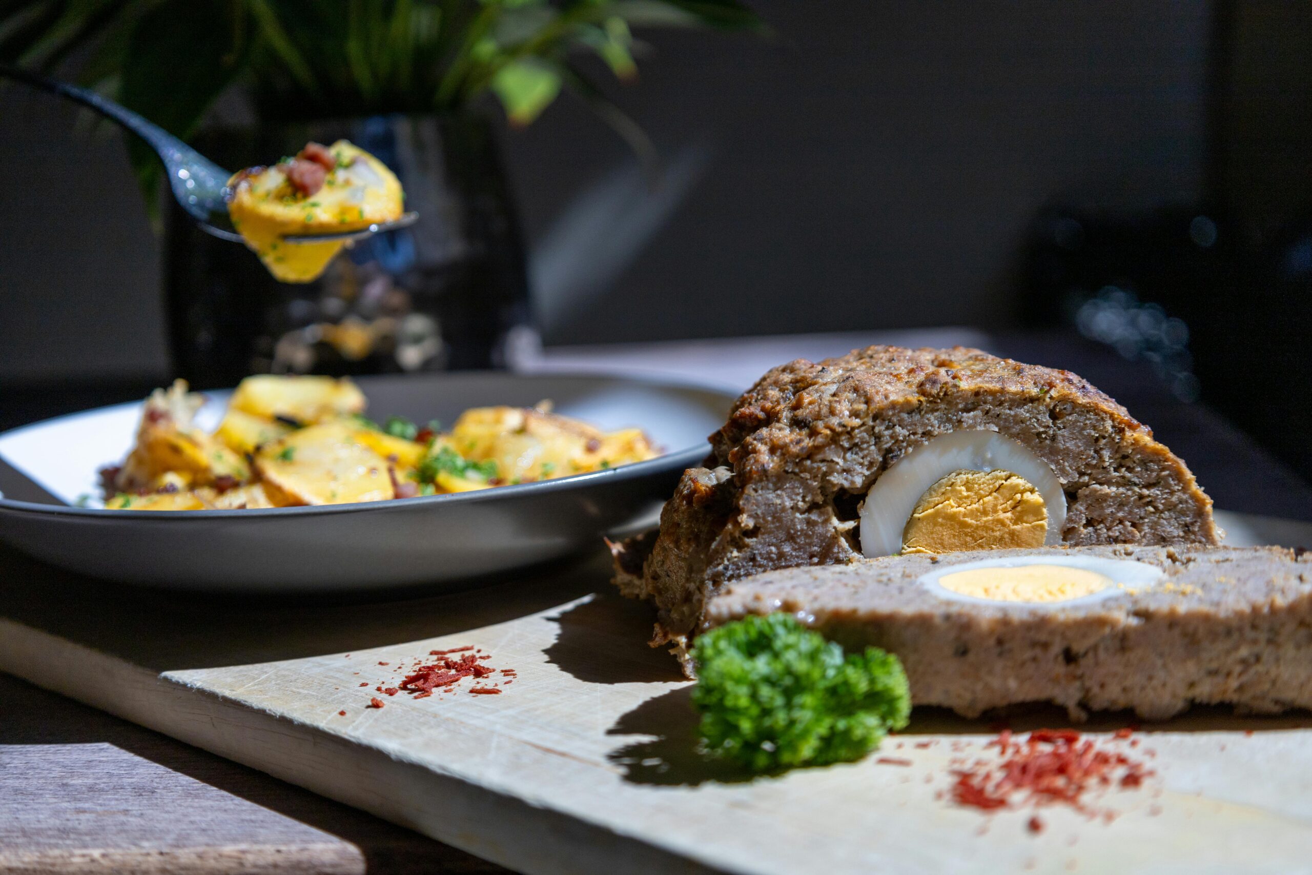 Leckerer Hackbraten mit Ei als Herzstück, serviert mit Kartoffeln. Perfekt für eine herzhafte Mahlzeit.