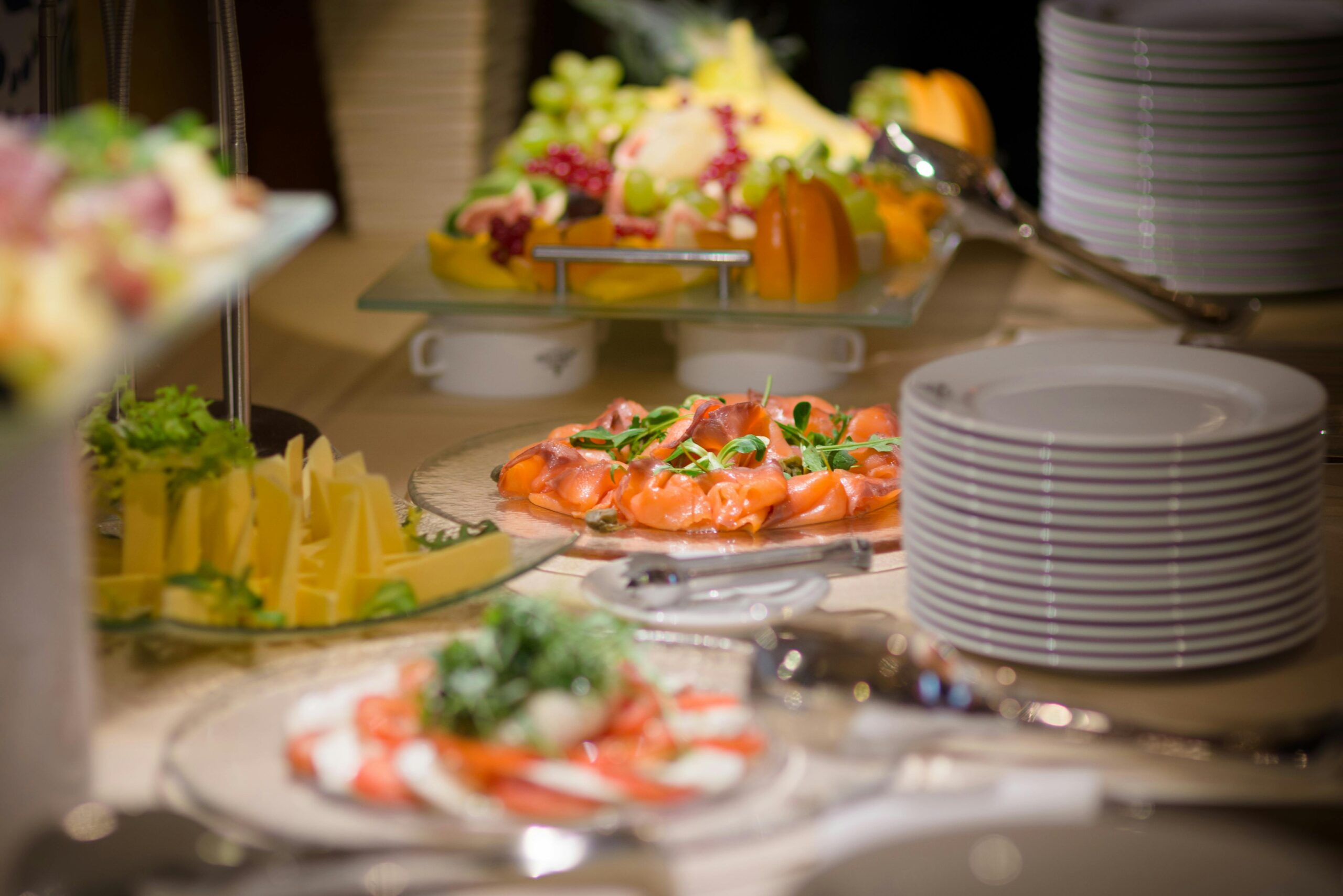 Luxuriöses Buffet mit geräuchertem Lachs, frischem Obst und Käseplatten.