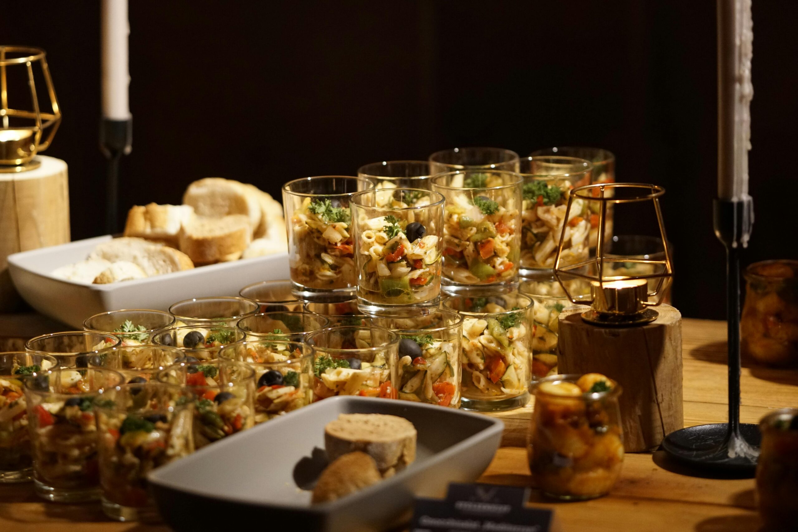 Ein wunderschön gedeckter Tisch mit Pasta-Häppchen in Gläsern, perfekt für Veranstaltungen.