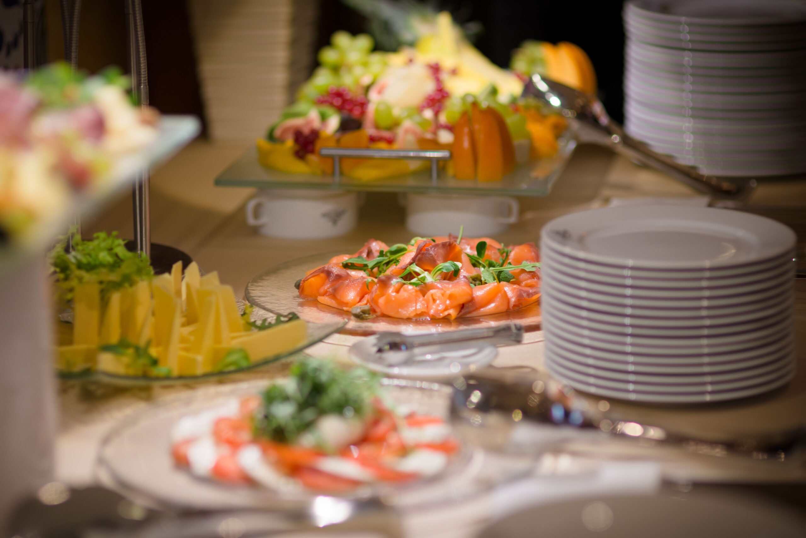 Luxuriöses Buffet mit geräuchertem Lachs, frischem Obst und Käseplatten.